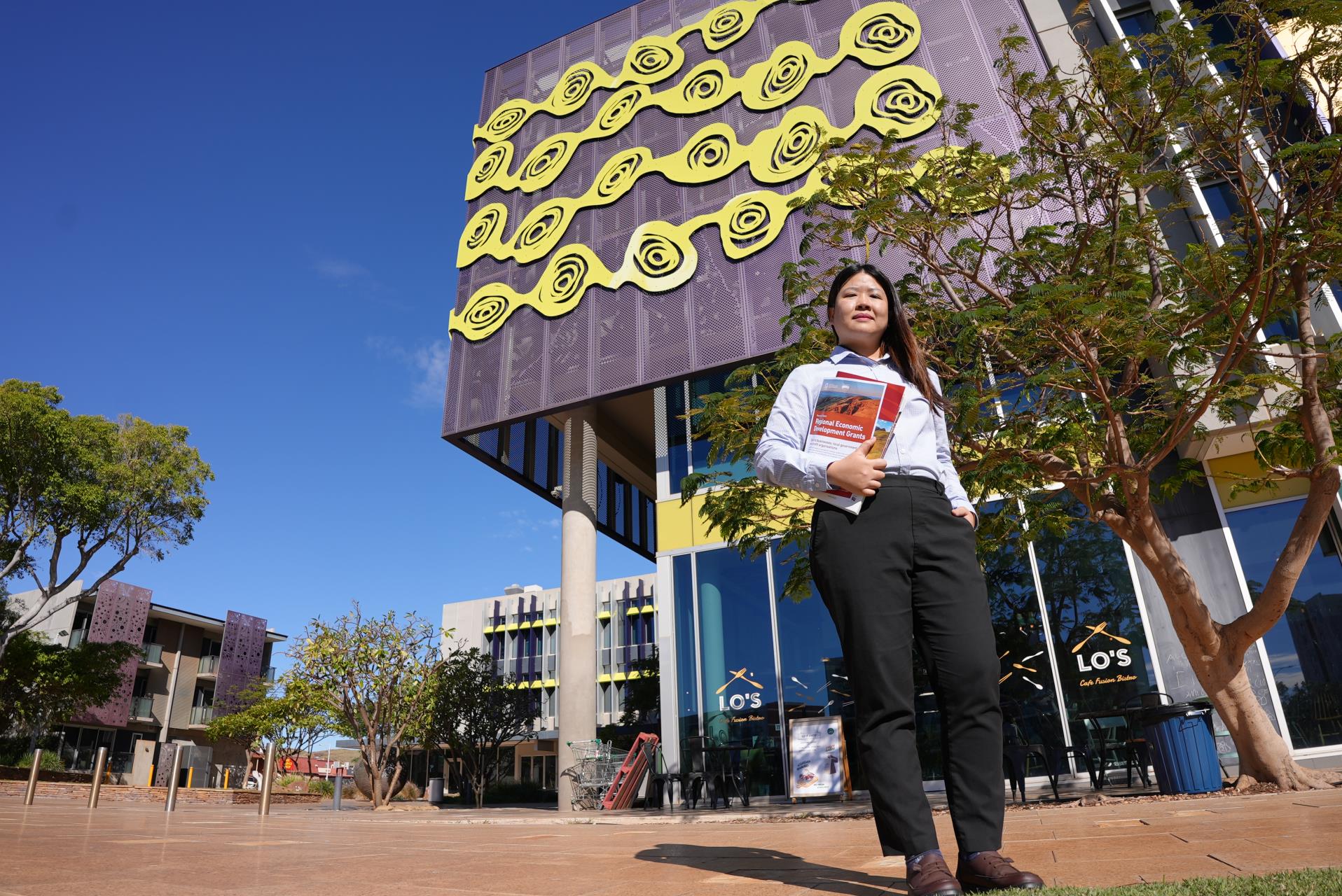A Pilbara Development Commission team member holding a folder of information about RED Grants